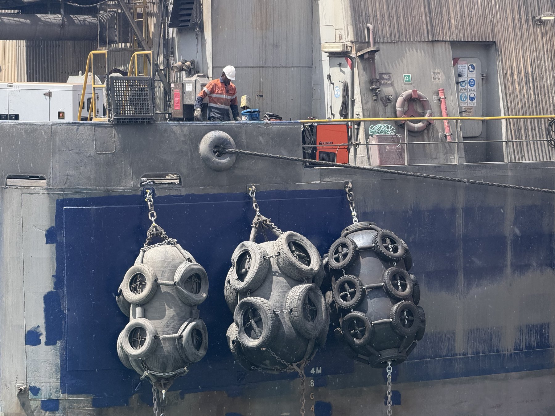Three tyre fenders rehung on new pad eyes over the freshly painted hull doubler plates